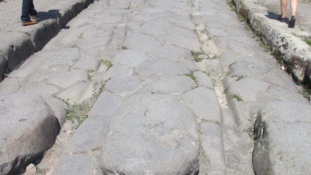 Wheel grooves left in road from all the carts that passed by, also notice the stepping stones